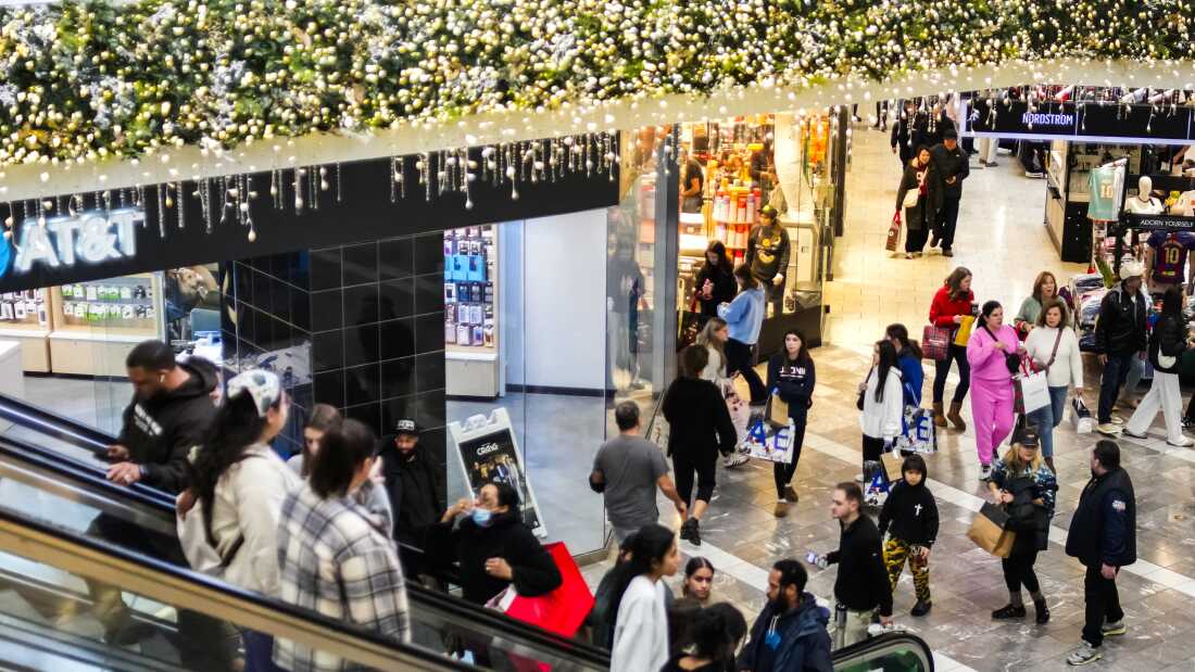 People visit Garden State Plaza during Black Friday shopping on Nov. 28, 2025, in Paramus, New Jersey. Holiday lights can be seen hanging above their heads.