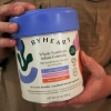 A person holds a container of ByHeart infant formula.
