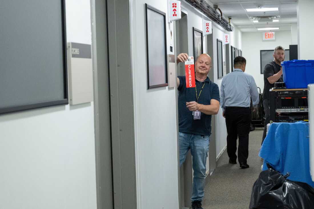 Neil Wallace signals that the Fox News staff has cleared the contents of their broadcast booth in the press area of the Pentagon, Wednesday, Oct. 15, 2025 in Washington.