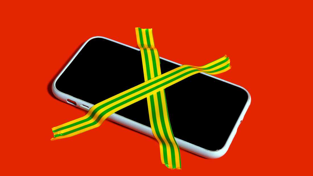Colorful still life of a banned smartphone with cross-hatched adhesive tape symbolizing digital detox and mindfulness
