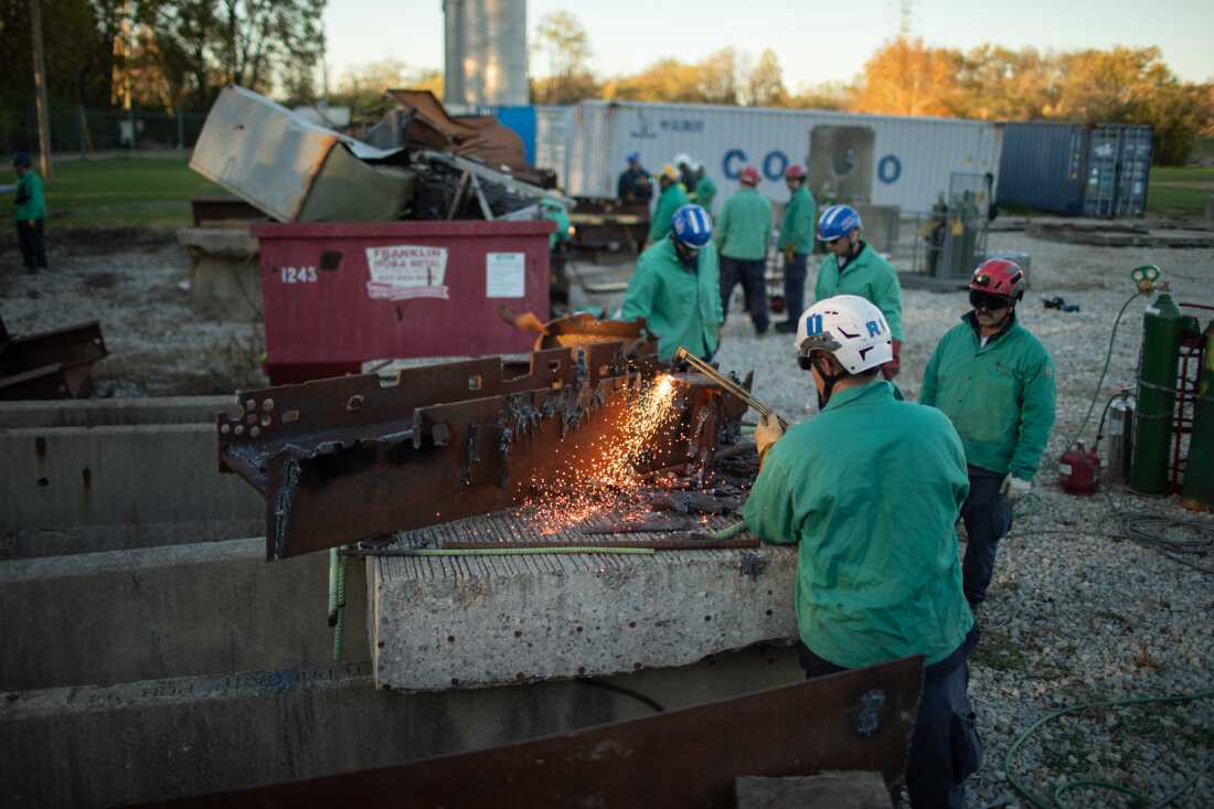 Search and rescue experts practice using torches to cut through steel beams.