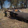Members of the Israeli security forces check the apparent remains of an Iranian ballistic missile lying on the ground on the outskirts of Qatzrin, Golan Heights, Israel.