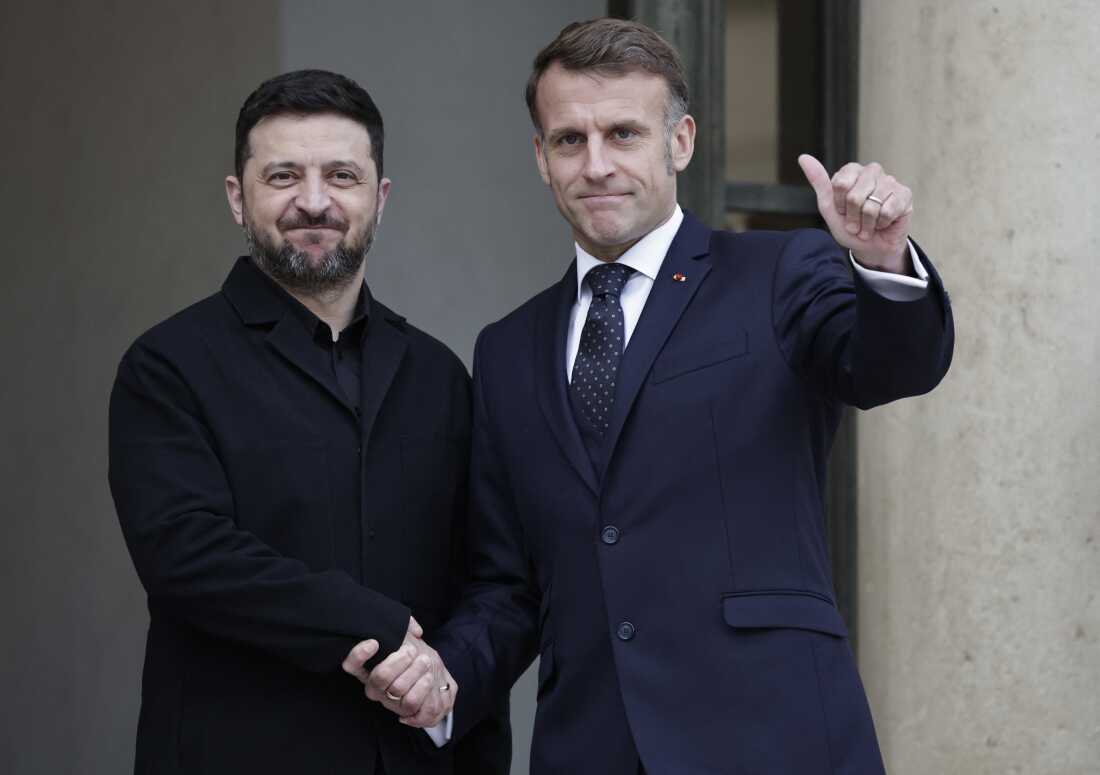 French President Emmanuel Macron (R) welcomes his Ukrainian counterpart, Volodymyr Zelenskyy, prior to their meeting at the Elysee palace in Paris on Dec. 1.