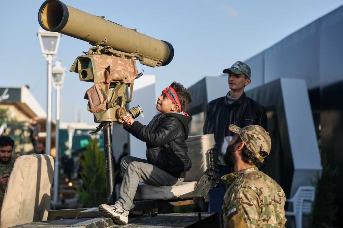 A boy checks out military equipment as visitors tour the "Syrian Revolution Military Exhibition," which opened last week ahead of the first anniversary of the ousting of the Bashar Assad regime in Damascus, Syria, Sunday.