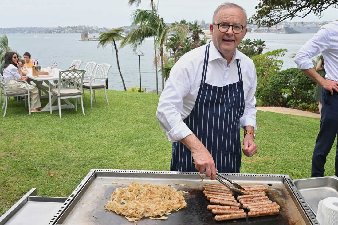Australian Prime Minister Anthony Albanese reacts as he cooks on a barbecue at an event to mark the beginning of the social media ban for children under 16 years of age, at Kirribilli House, in Sydney, Australia, Wednesday, Dec. 10, 2025.