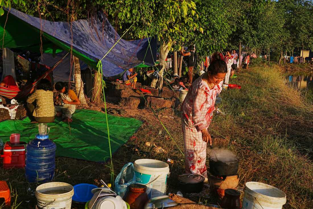 People prepare breakfast as they take refuge at Wat Chroy Neangoun's Buddhist pagoda in Siem Reap province, Cambodia Friday, Dec. 12, 2025, after fleeing from home following fighting between Thailand and Cambodia over territorial claims.