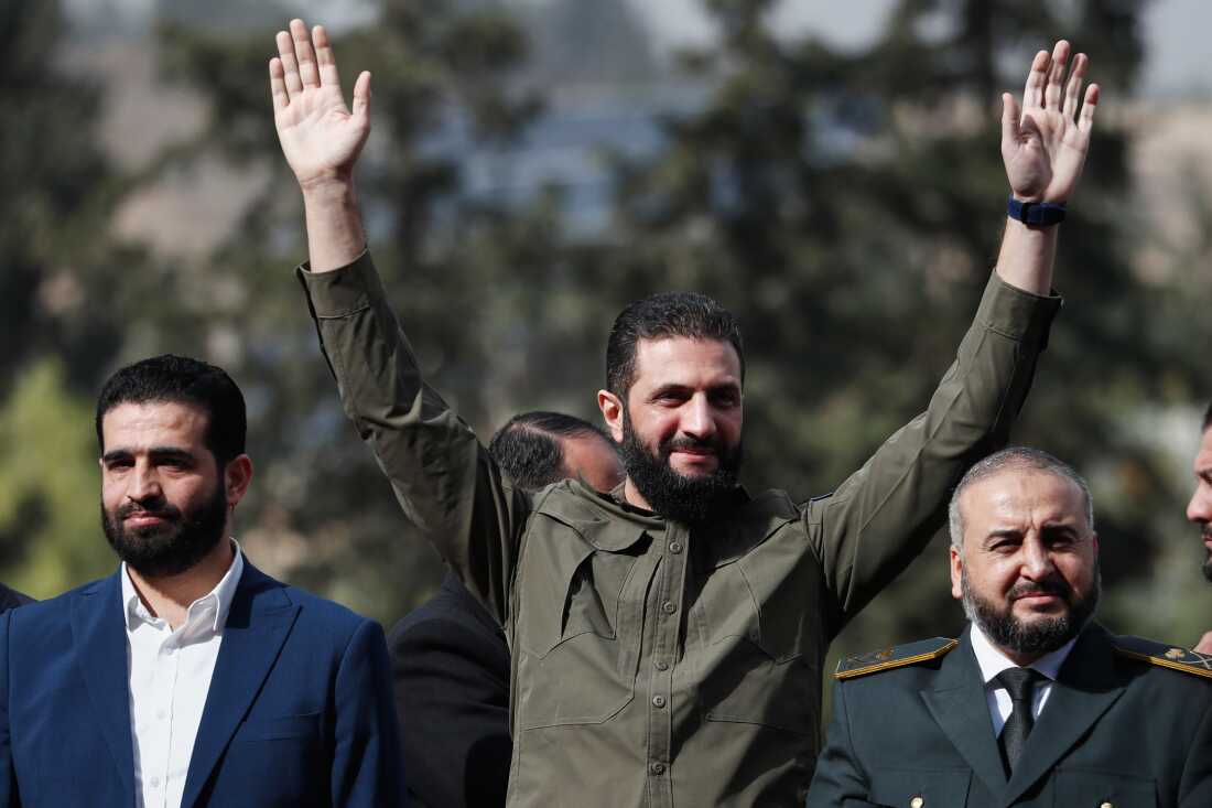 Syria's interim president, Ahmed al-Sharaa, greets people as he attends celebrations marking the first anniversary of the ousting of former President Bashar al-Assad in Damascus, Syria, Monday.