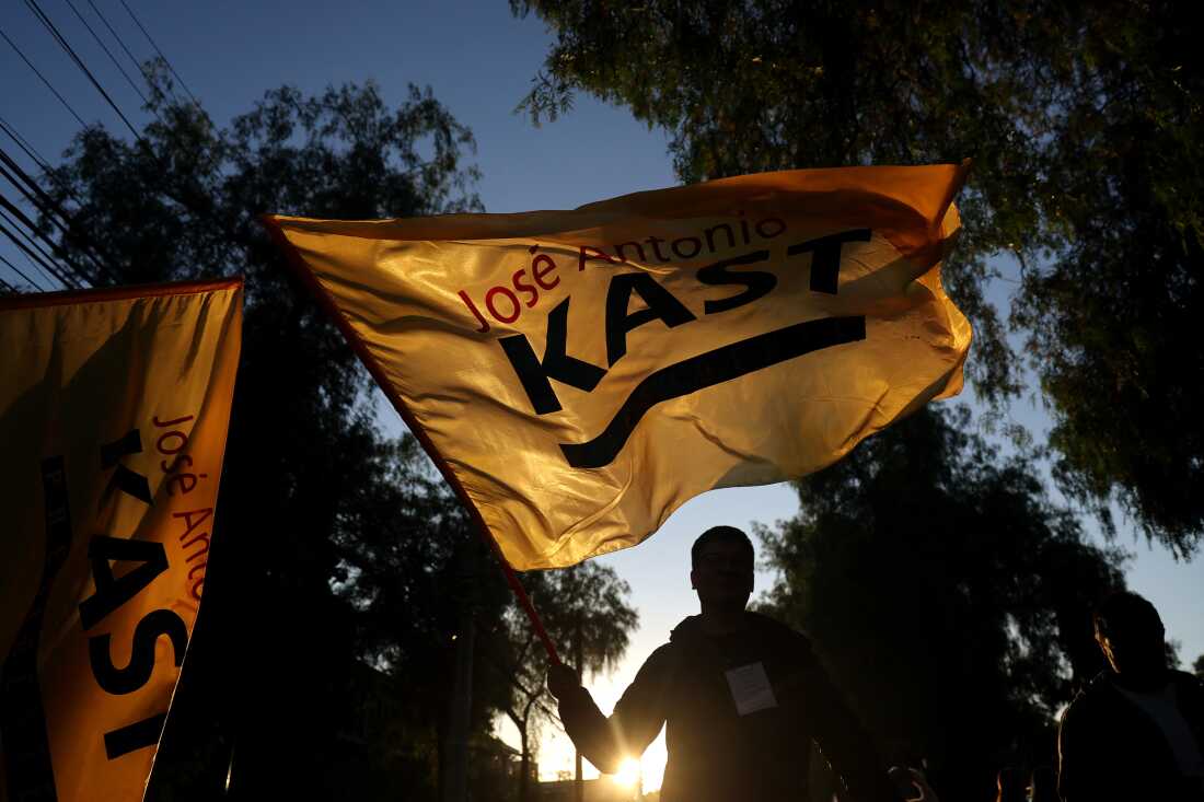 A supporter of Chile's presidential candidate Jose Antonio Kast, of the Partido Republicano party, waves a flag celebrating the first results of the presidential runoff election in Santiago on December 14, 2025. Chilean voters elected Jose Antonio Kast, the most right-wing president in 35 years of democracy, with a thumping 58 percent of votes and his rival Jeannette Jara conceding defeat, according to official results on December 14, 2025. (Photo by Javier TORRES / AFP via Getty Images)