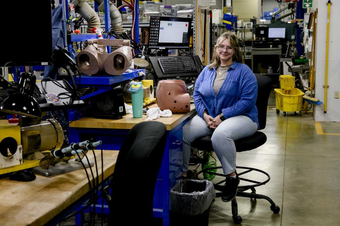 Katie Burlovich, a molded product trimmer, sits at her station before sanding the pelvis of a crash test dummy.