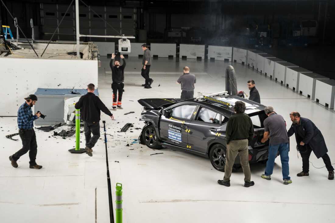 IIHS staff clear debris and document results after a crash test.