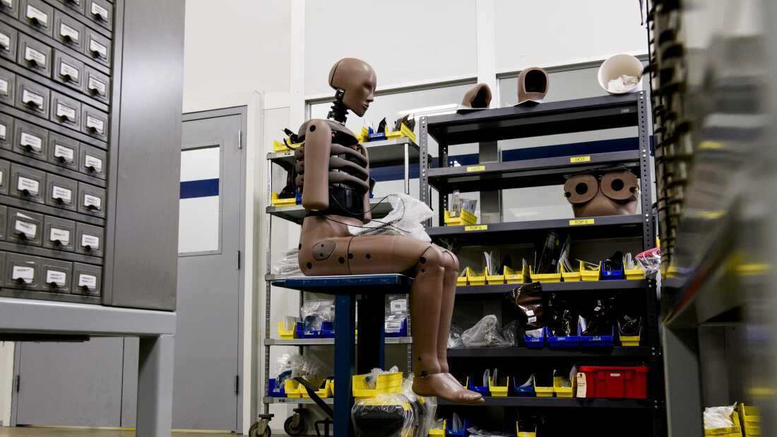 An assembled crash test dummy sits on a moveable desk in the assembly area at a Humanetics production facility in Huron, Ohio.