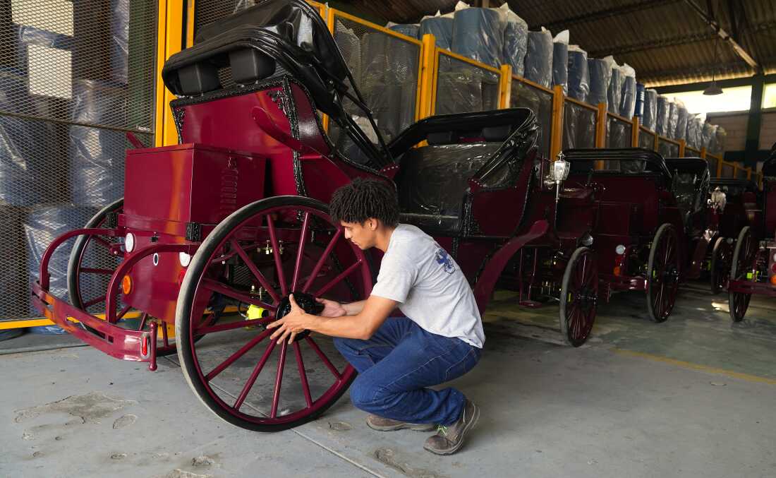A worker fixes a wheel on one of the electric carriages that Cartagena’s municipal government has imported from China.