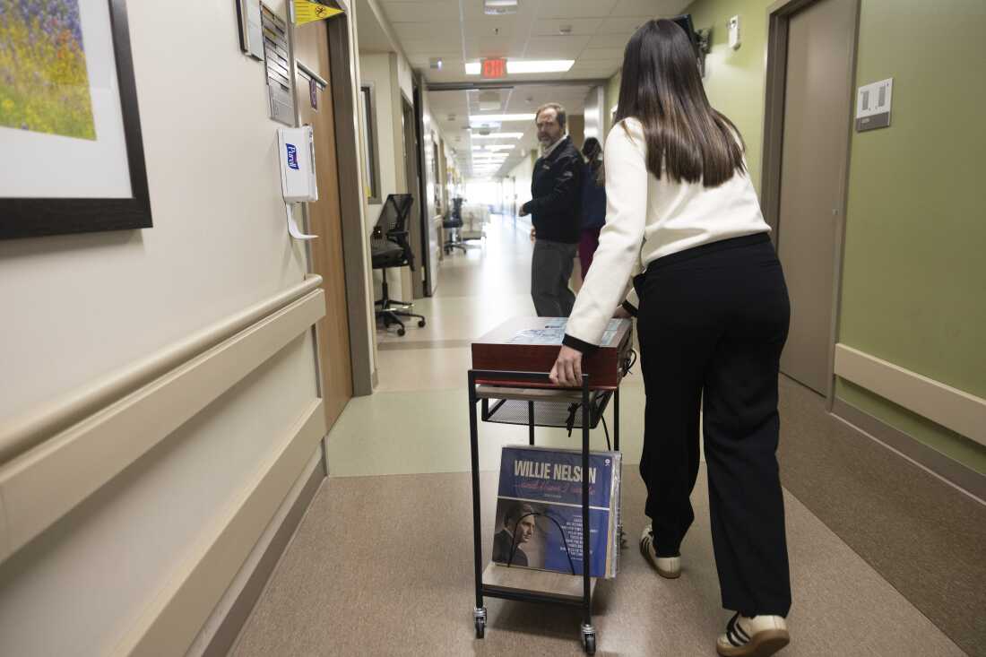 UT Public Health Sophomore Daniela Vargas pushes a cart through Dell Seton Medical Center on December 9, 2025. The ATX VINyL program is designed to bring volunteers in to play music for patients in the hospital, and Vargas participates as the head volunteer. Lorianne Willett/KUT News