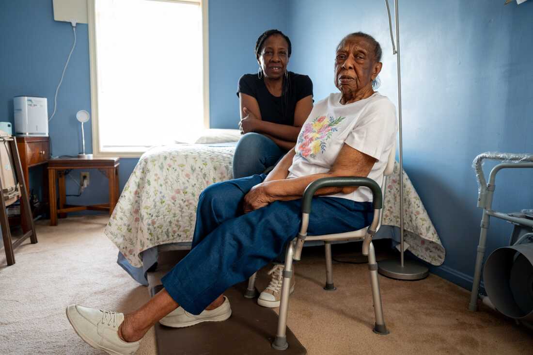 Cookie Jones (left) sits with her mother, Valerie (right), in Cookie's home on June 4, 2025, in Bridgeport, Conn. Cookie Jones quit her job to care for her mother, who has Alzheimer's disease. She is one of thousands of unpaid family caregivers in Connecticut navigating financial and access barriers to treatment.