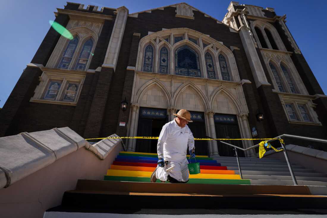 Robert Garcia paints the stairs of Oak Lawn United Methodist Church in Pride and trans colors Wednesday, Oct. 22, 2025, in Dallas, Texas. The church made the move in response to Gov. Greg Abbott’s order to remove symbols from crosswalks in Texas cities.