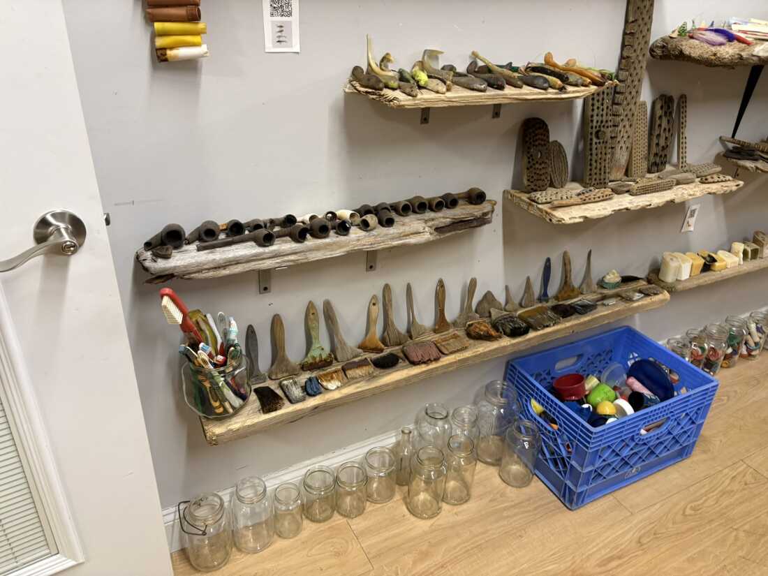 Among the detritus displayed at the Plum Island Museum of Lost Toys & Curiosities are Colonial-era pipes (far left), and the driftwood paddles that are the remains of scrub brushes and hair brushes (right) which stand in contrast to the brightly colored plastic brushes (bottom left) that remain fully intact.
