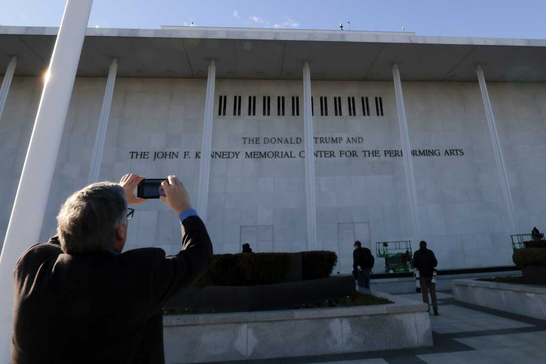 An individual photographs the new sign outside of the “John F. Kennedy Memorial Center for the Performing Arts" now including "The Donald J. Trump" as seen on December 19, 2025 in Washington, DC. 