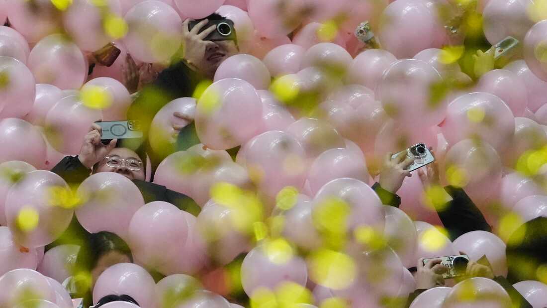 Reveler use their smartphones to film the falling balloons and confetti as they celebrate the start of 2026 during the New Year countdown event held at a shopping mall in Beijing, early Thursday, Jan. 1, 2026. (AP Photo/Andy Wong)