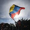 A person flutters a national flag in Caracas.