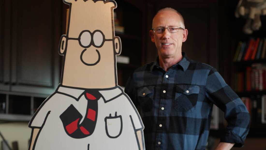 Cartoonist Scott Adams poses with his a life-size cutout of his creation, Dilbert, in 2014.