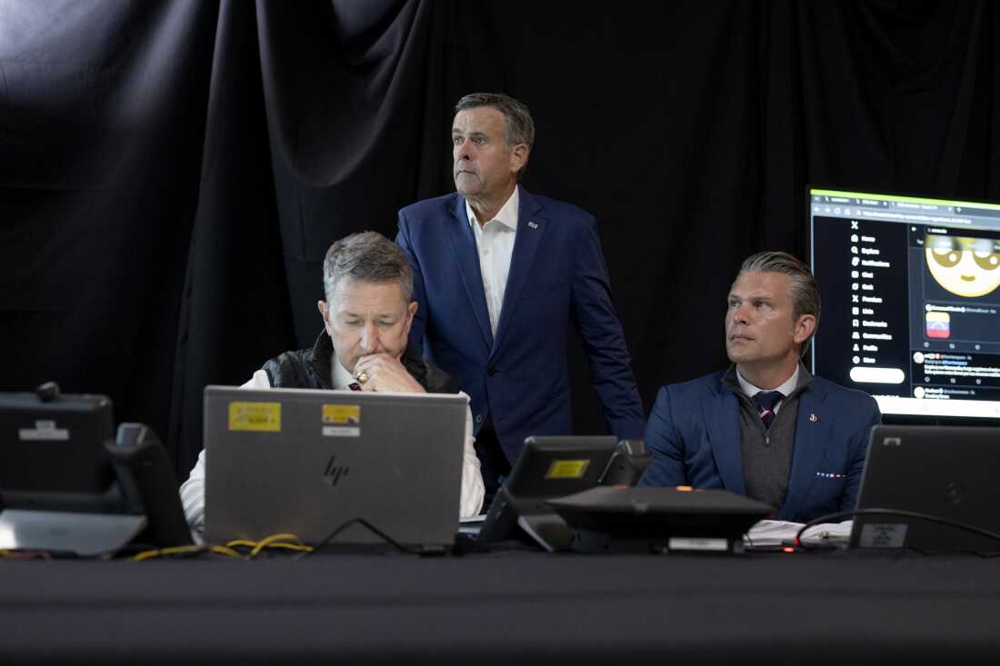 In an image provided by the White House, Chairman of the Joint Chiefs of Staff Gen. Dan Caine, left, CIA Director John Ratcliffe, center, and Secretary of Defense Pete Hegseth, right, monitor U.S. military operations in Venezuela on Jan. 3 from President Trump's Mar-a-Lago club in Florida. On Hegseth's right is a display featuring a search for "Venezuela" on the social media platform X.