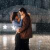 Actors Kate Beckinsale and John Cusack embrace one another in the rain in the 2001 film Serendipity. Her hands are around his shoulders, and his hands are around her waist.