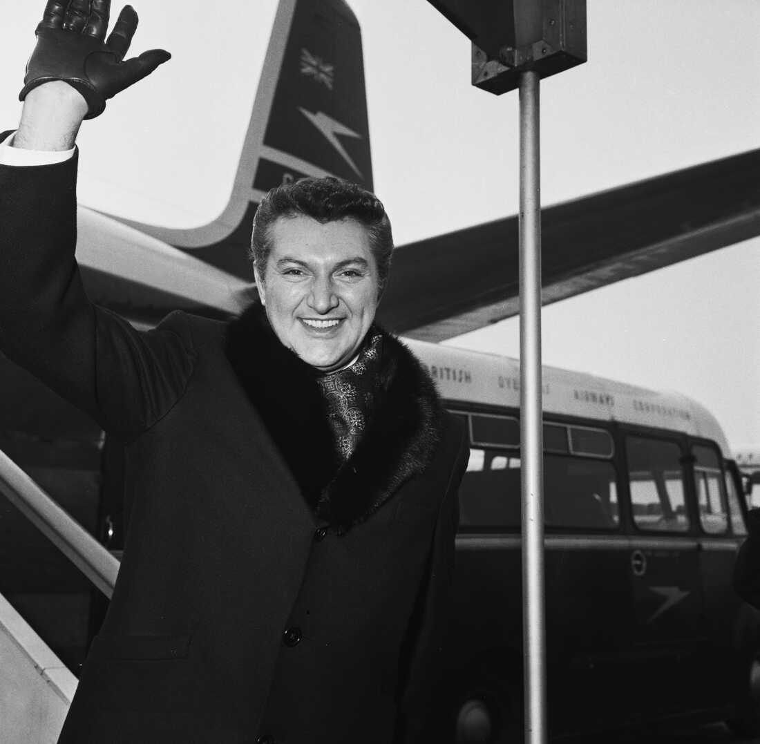 American pianist Liberace (Władziu Valentino Liberace, 1919-1987), waves as he descends the stairs of his plane on a visit to Britain, London Airport, March 30th, 1960.