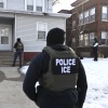ICE agents approach a house before detaining two people on Jan. 13 in Minneapolis.