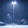 Snow falls on an empty parking lot outside a supermarket in December in Northvale, N.J.