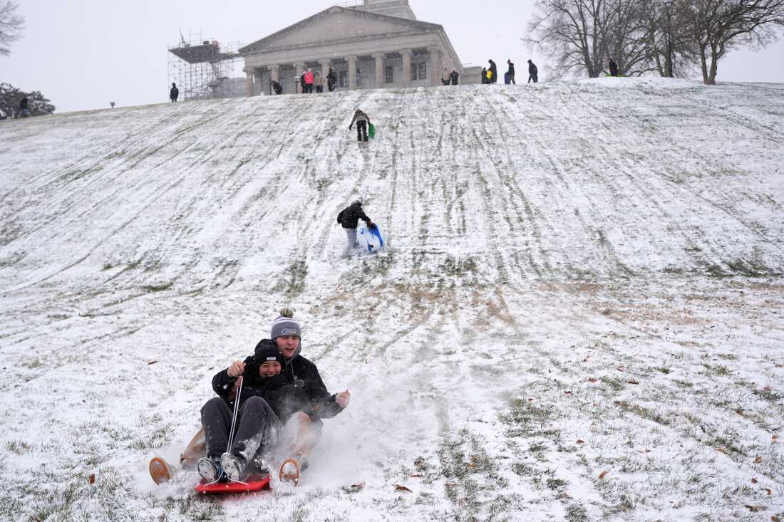 Yana Beeker, front, Roddy Peterson, behind, sled down a hill at the state Capitol during a winter storm Saturday, Jan. 24, 2026, in Nashville, Tenn.