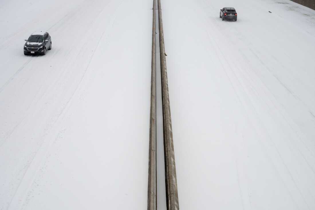 Cars drive in the snow on Interstate 630 in Little Rock, Arkansas. 