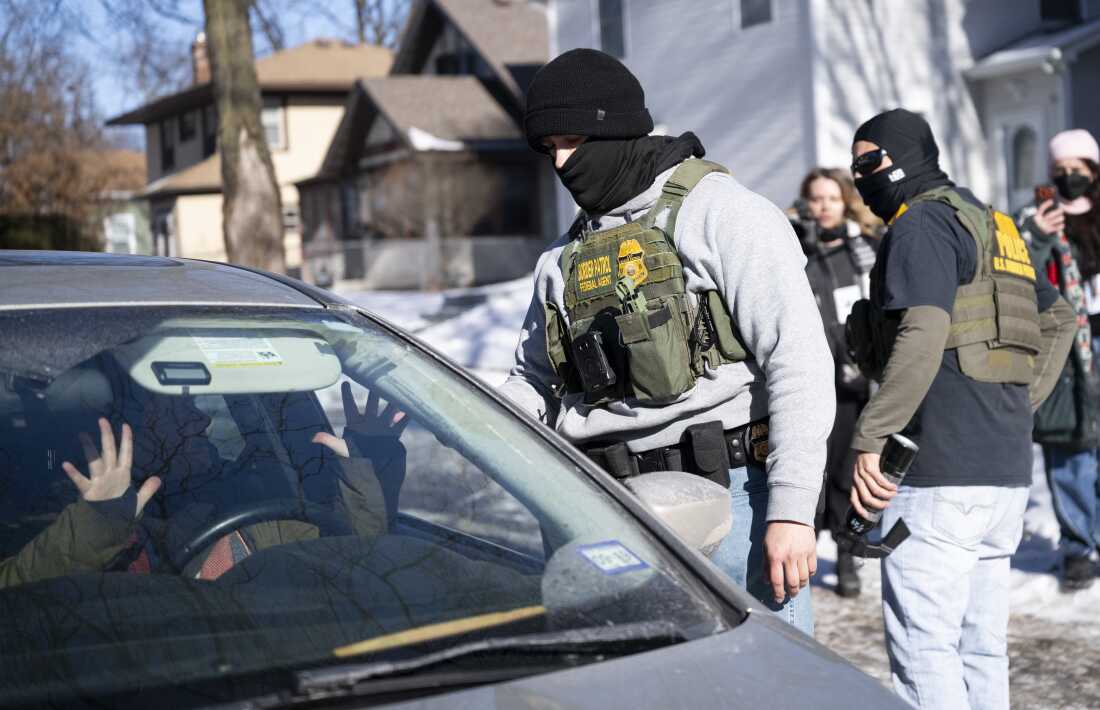 A member of the U.S. Border Patrol confronts the driver of a vehicle that was following them on Jan. 29, in Minneapolis. Democrats want to immigration officers to not cover their faces and wear body cameras, among other changes.