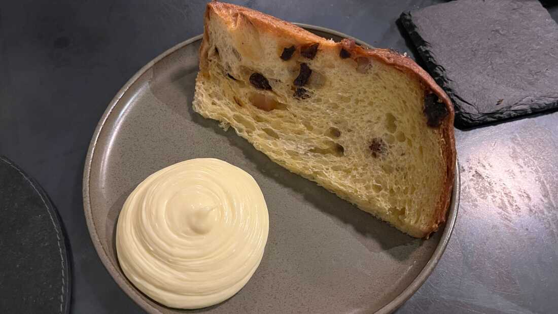 A slice of fruitcake with a plop of cream.