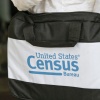 The U.S. Census Bureau’s logo is featured on a black bag carried by a census worker knocking on doors in 2020 in Winter Park, Florida.